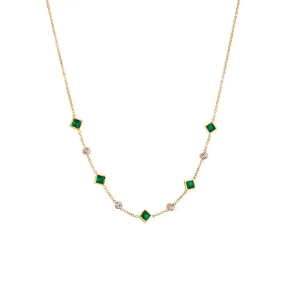 Colar geométrico dourado com esmeraldas, estilo estação, da marca Rose & Oliver, com pingentes de formas modernas.