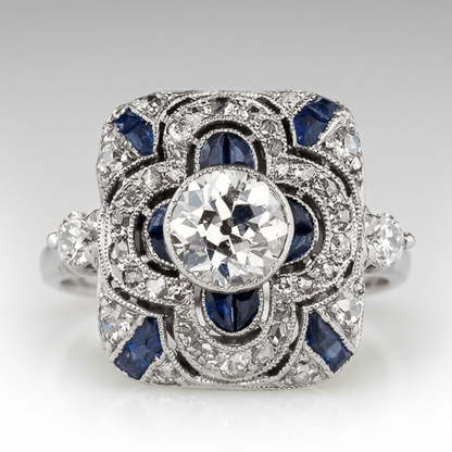 Anillo vintage de plata con diamantes y zafiro azul, diseño elegante de la marca Rose & Oliver, destacado en la imagen.