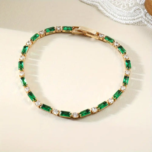 Pulseira de tênis com elos de ouro e esmeraldas alternadas, da marca Rose & Oliver, com detalhes elegantes e sofisticados.