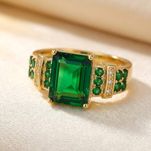 Anel de ouro com esmeraldas e pedras multicoloridas da marca Rose & Oliver, mostrando detalhes das pedras e acabamento elegante.