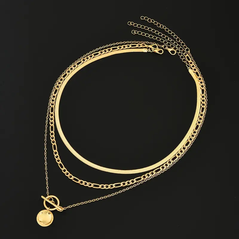 Colar dourado Rose & Oliver Savira com camadas texturizadas e detalhes de moedas em destaque.