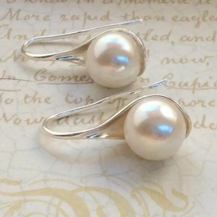 Aretes de oro elegantes con perlas, estilo drop, de la marca Rose & Oliver, presentados con detalles delicados y acabado refinado