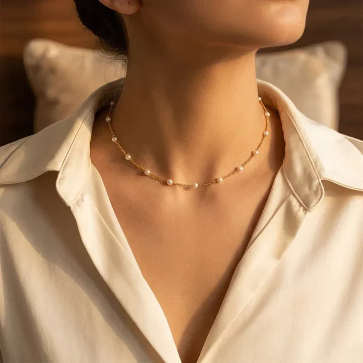 Collar de perlas doradas con espacio, diseño elegante de Rose & Oliver, sobre fondo neutro.