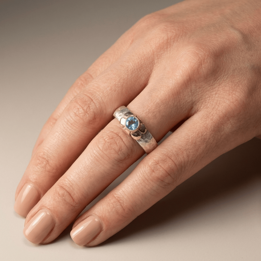 Anillo de plata de dos colores con topacio azul hecho a mano, de Rose & Oliver, mostrado en la imagen.