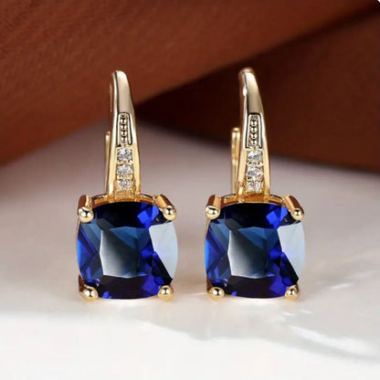 Aretes de argolla con piedra zafiro mística, hechos por Rose & Oliver, con acabamiento elegante y detalles brillantes.
